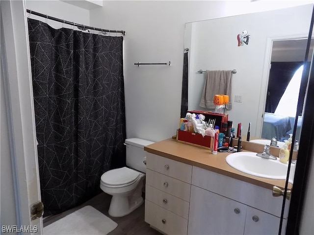 bathroom with curtained shower, vanity, and toilet