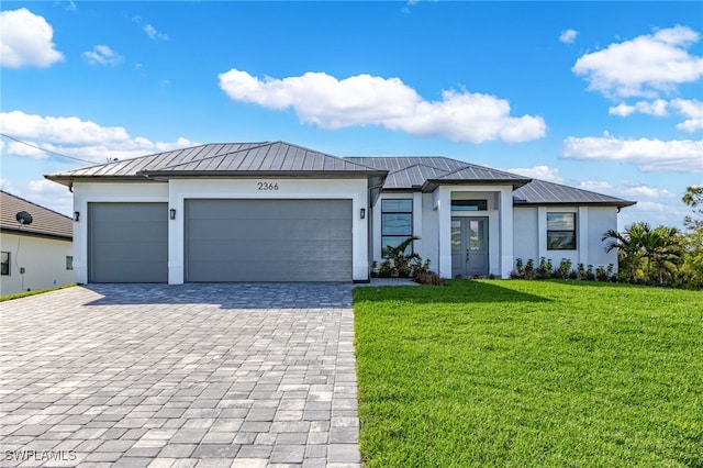 view of front of property featuring a garage, metal roof, a standing seam roof, and stucco siding