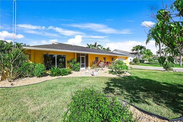 back of property featuring a garage, concrete driveway, a lawn, and stucco siding