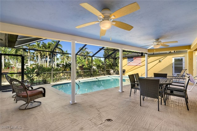 outdoor pool with glass enclosure, a patio area, and ceiling fan