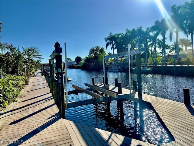 dock area with a water view and boat lift