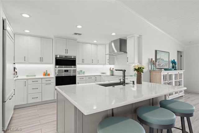 kitchen with lofted ceiling, wall chimney range hood, visible vents, and crown molding