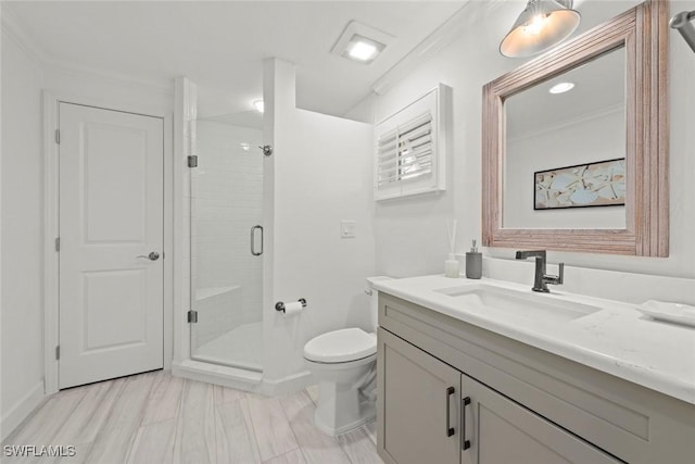 bathroom with crown molding, toilet, a stall shower, vanity, and baseboards