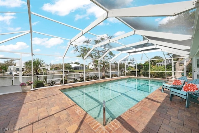 outdoor pool featuring glass enclosure and a patio