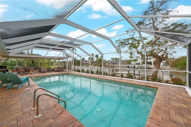 outdoor pool featuring glass enclosure and a patio