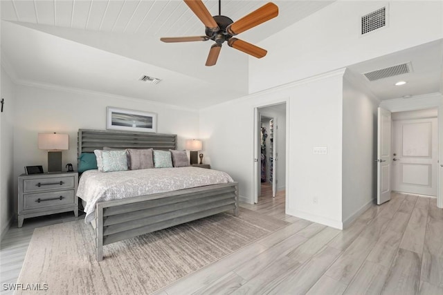 bedroom featuring light wood finished floors, visible vents, and ornamental molding