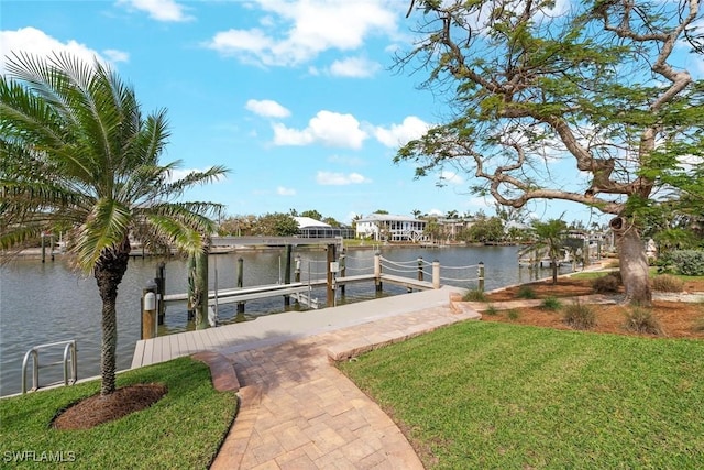 view of dock with a water view, boat lift, and a yard