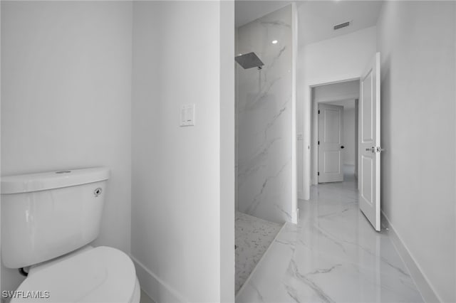 bathroom featuring toilet, visible vents, baseboards, marble finish floor, and a marble finish shower