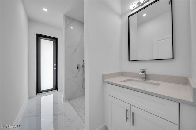 bathroom featuring marble finish floor, a marble finish shower, recessed lighting, vanity, and baseboards