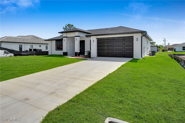 prairie-style house featuring an attached garage, cooling unit, driveway, stucco siding, and a front yard