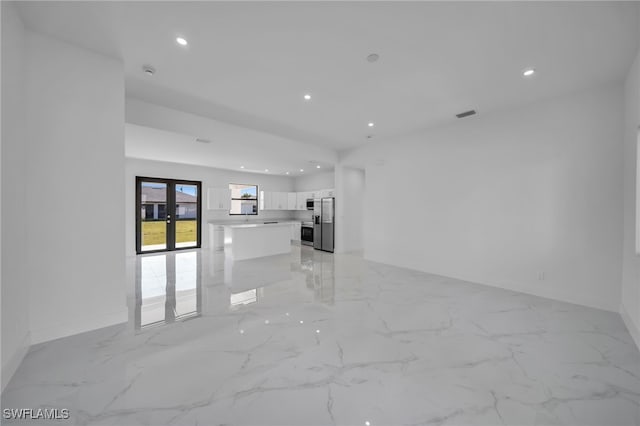 unfurnished room featuring marble finish floor, french doors, and recessed lighting