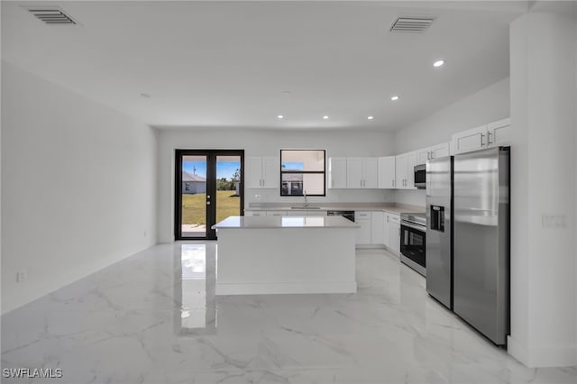 kitchen with marble finish floor, stainless steel appliances, a sink, and visible vents