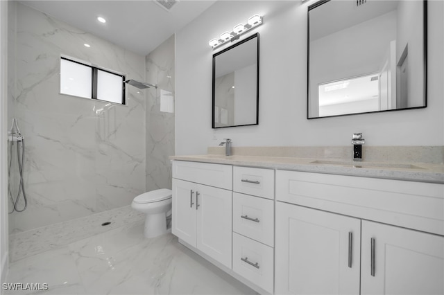 full bathroom featuring double vanity, a marble finish shower, toilet, marble finish floor, and a sink