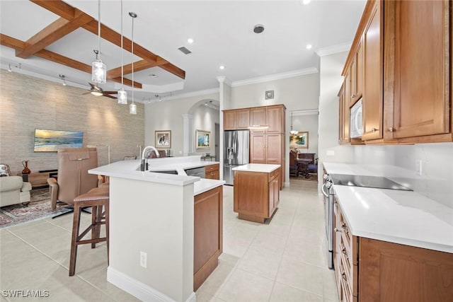 18191 Parkside Greens Dr, Fort Myers, FL 33908 - kitchen with a spacious island, appliances with stainless steel finishes, light tile patterned floors, brown cabinetry, and crown molding