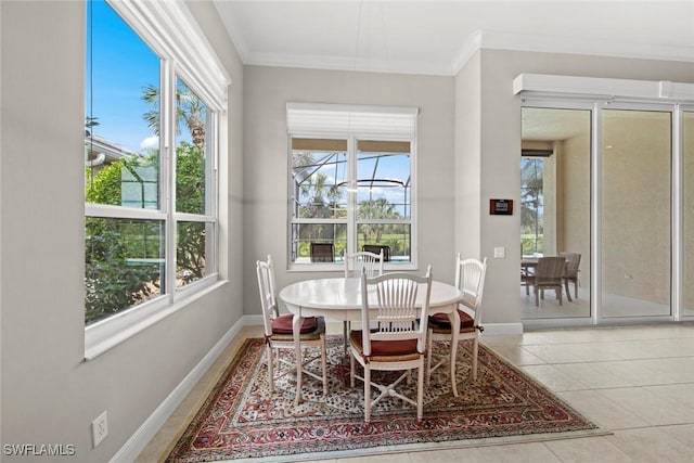 dining area with tile patterned flooring, ornamental molding, and baseboards