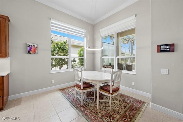 dining room with baseboards, light tile patterned flooring, and crown molding