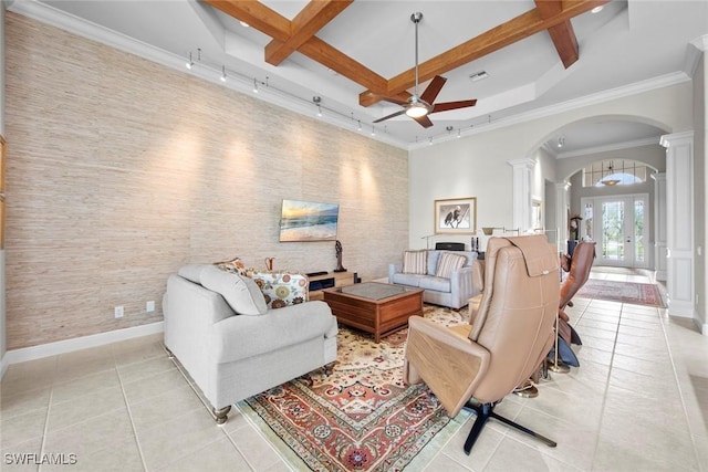 living room featuring arched walkways, coffered ceiling, ornate columns, and light tile patterned floors