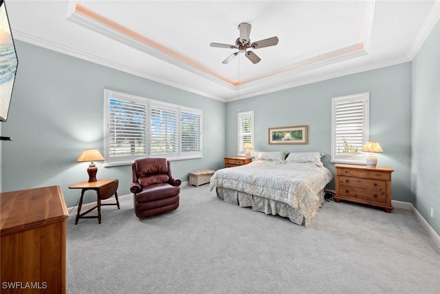 bedroom with carpet floors, baseboards, ornamental molding, and a raised ceiling