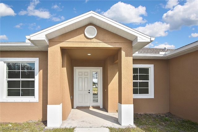 entrance to property with stucco siding