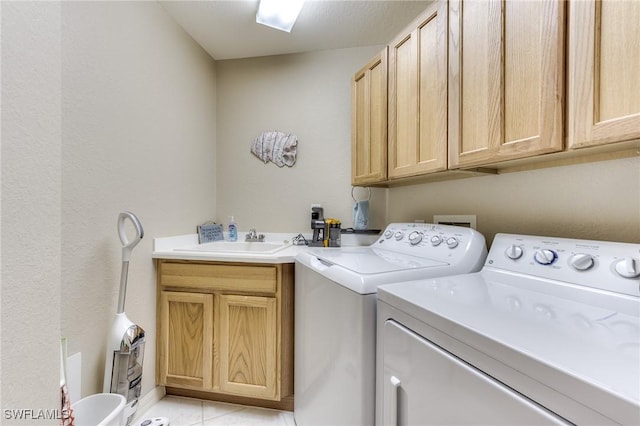 laundry room with light tile patterned floors, independent washer and dryer, a sink, and cabinet space