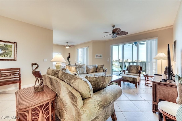 living area with light tile patterned floors, ceiling fan, ornamental molding, and baseboards