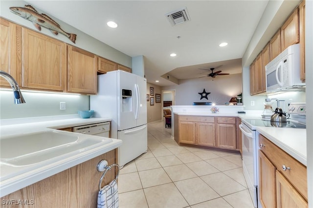 kitchen featuring light countertops, visible vents, light tile patterned flooring, white appliances, and a peninsula