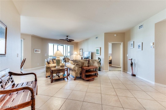 living room with ceiling fan, light tile patterned flooring, visible vents, and baseboards