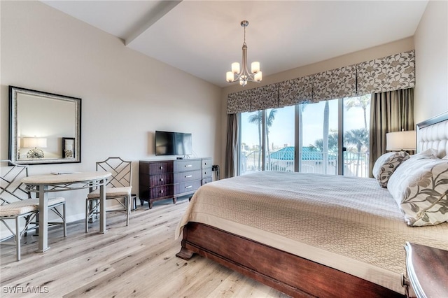 bedroom with a chandelier, light wood finished floors, and lofted ceiling