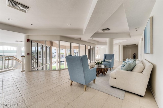 living room featuring visible vents, plenty of natural light, and light tile patterned floors