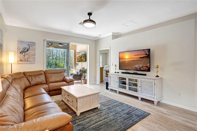 living area with ornamental molding, ceiling fan, light wood-style flooring, and baseboards