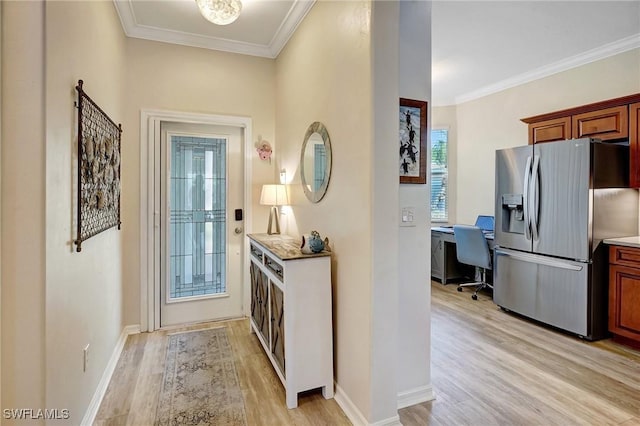 doorway featuring ornamental molding, light wood-style flooring, and baseboards