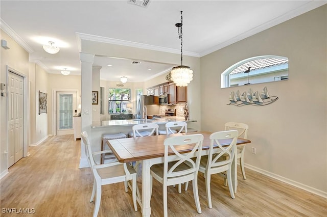 dining area with light wood-type flooring, decorative columns, baseboards, and ornamental molding