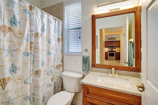 bathroom with curtained shower, vanity, and toilet