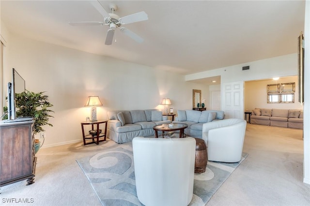 living room featuring light carpet, baseboards, visible vents, and a ceiling fan