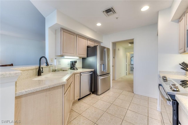 kitchen with visible vents, appliances with stainless steel finishes, light brown cabinetry, a sink, and light tile patterned flooring