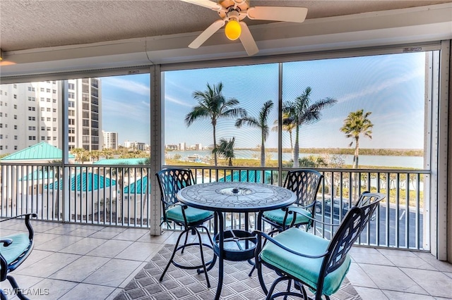 sunroom / solarium featuring a view of city and a ceiling fan