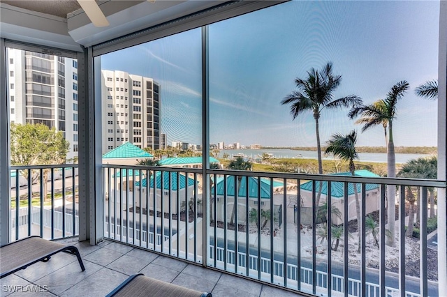 balcony featuring a water view, a view of city, and a ceiling fan