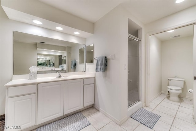 bathroom featuring toilet, vanity, baseboards, tile patterned floors, and a stall shower