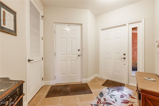 entrance foyer featuring baseboards and light tile patterned flooring