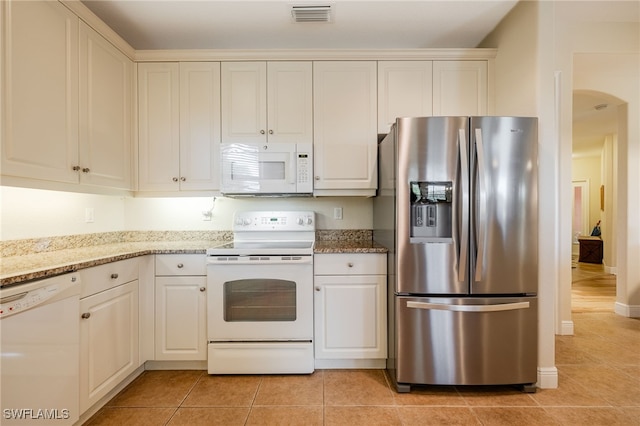 kitchen featuring white appliances, white cabinetry, light tile patterned floors, and visible vents