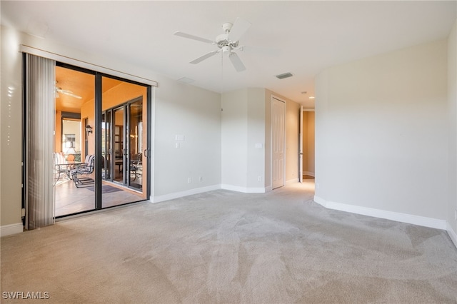 carpeted empty room featuring visible vents, ceiling fan, and baseboards