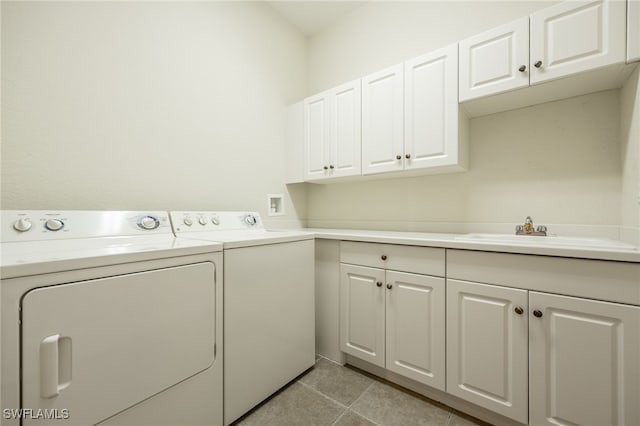 laundry room with light tile patterned floors, independent washer and dryer, a sink, and cabinet space