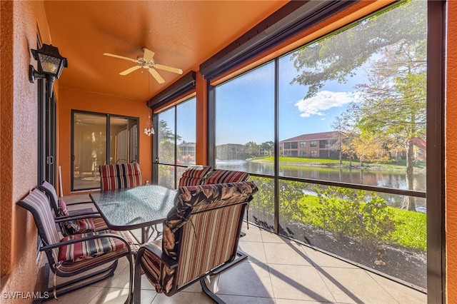 sunroom featuring a water view and ceiling fan