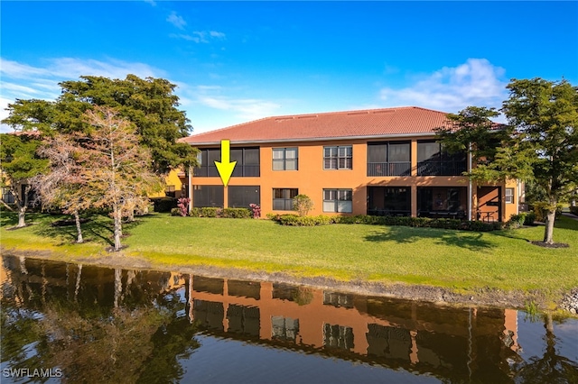 back of house featuring a water view and a yard