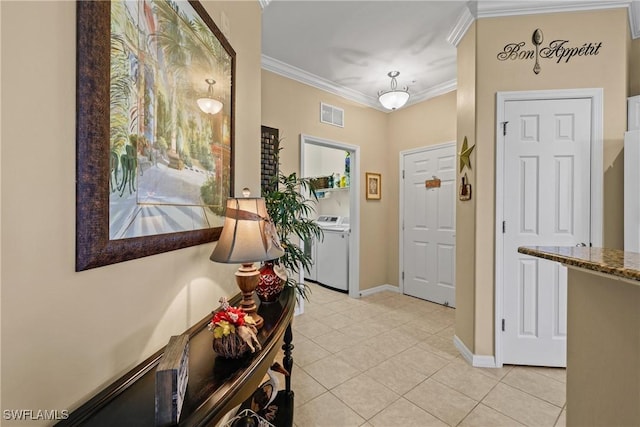 foyer entrance featuring light tile patterned flooring, visible vents, washing machine and clothes dryer, and ornamental molding