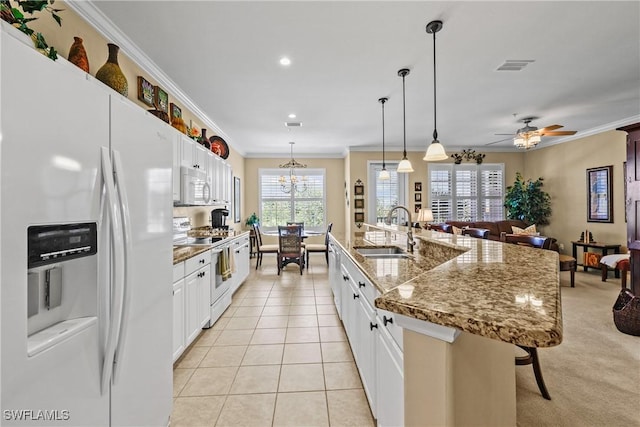 kitchen with light tile patterned floors, visible vents, open floor plan, a sink, and white appliances