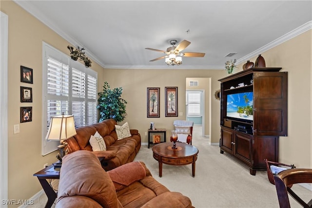 living area featuring light carpet, baseboards, a ceiling fan, and crown molding