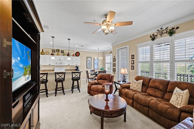 living area featuring light colored carpet, ceiling fan with notable chandelier, visible vents, baseboards, and ornamental molding