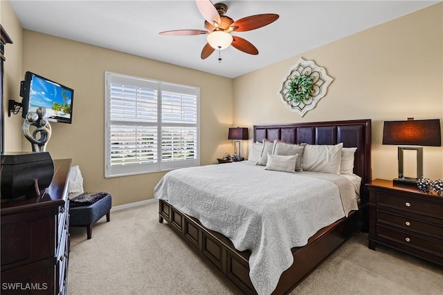 bedroom with light carpet, a ceiling fan, and baseboards