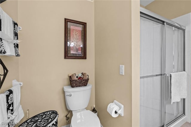 bathroom featuring a shower stall and toilet